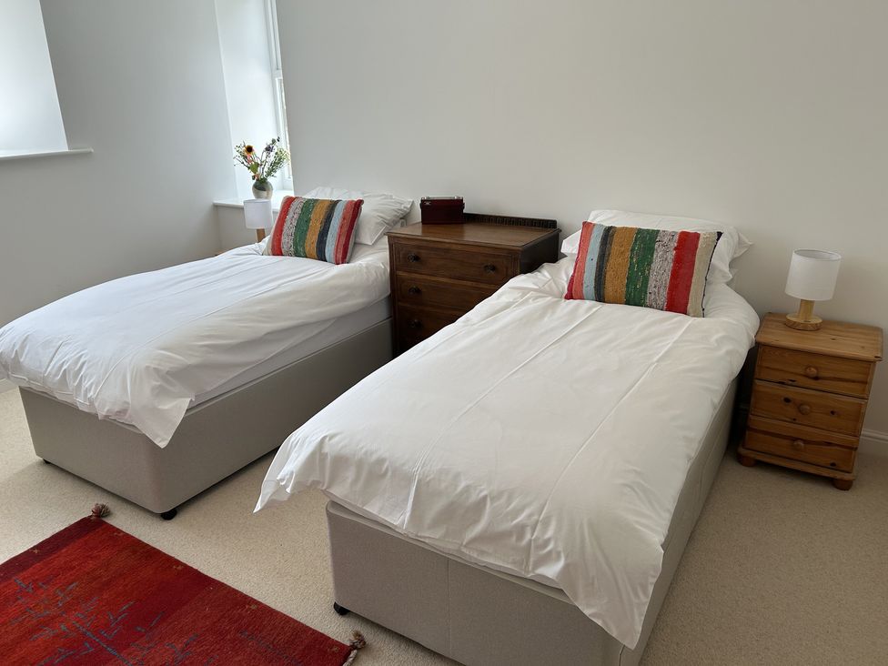 A bedroom with two beds and a nightstand at High Meadow Barn Thornton Rust near Bainbridge