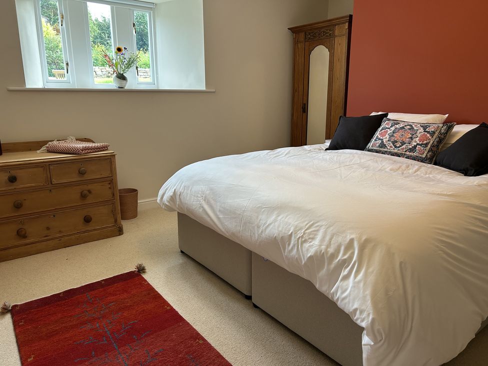 A bedroom with a bed and dresser at High Meadow Barn Thornton Rust near Bainbridge
