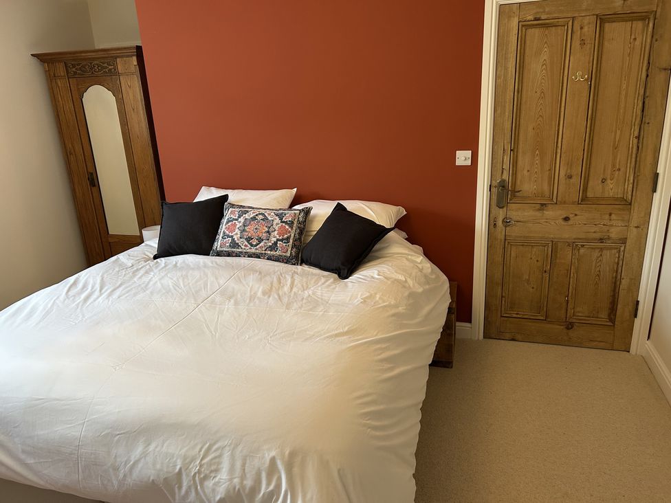 A bedroom with a bed and wardrobe at High Meadow Barn Thornton Rust near Bainbridge