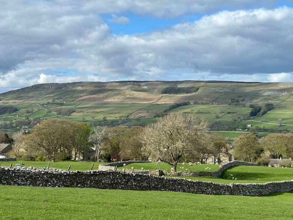 A landscape view with a mountain and fields at High Meadow Barn in Thornton Rust near Bainbridge