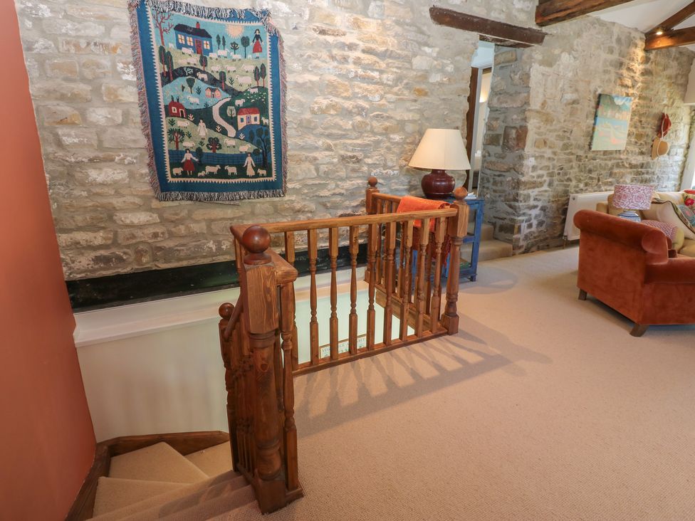 A hallway with a staircase and decorative rug at High Meadow Barn Thornton Rust near Bainbridge