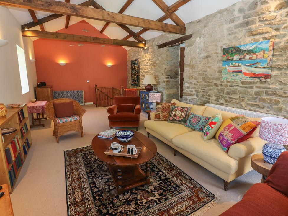 A living room with a sofa, coffee table, and chairs at High Meadow Barn Thornton Rust near Bainbridge