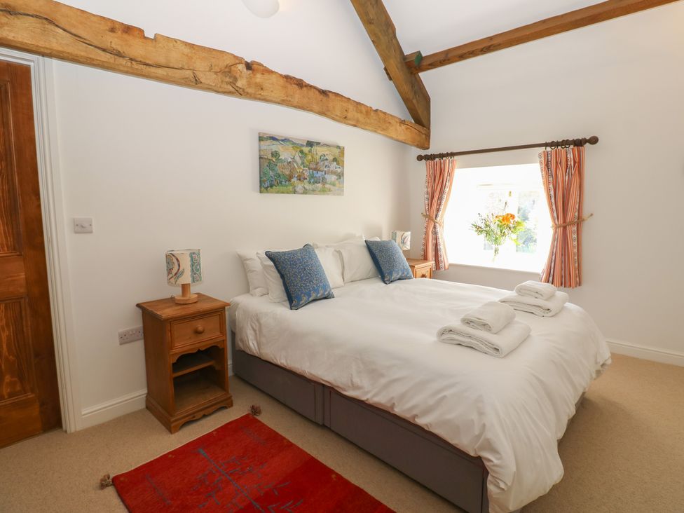 A bedroom with a bed and nightstand at High Meadow Barn Thornton Rust near Bainbridge