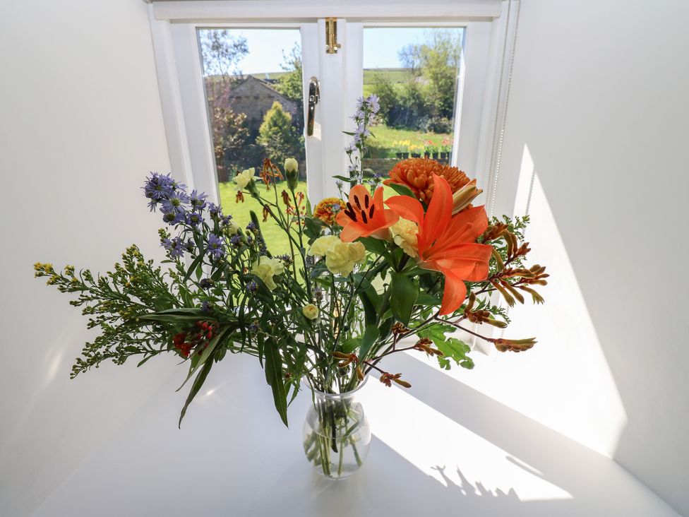 A bouquet of flowers in a vase near a window at High Meadow Barn Thornton Rust near Bainbridge