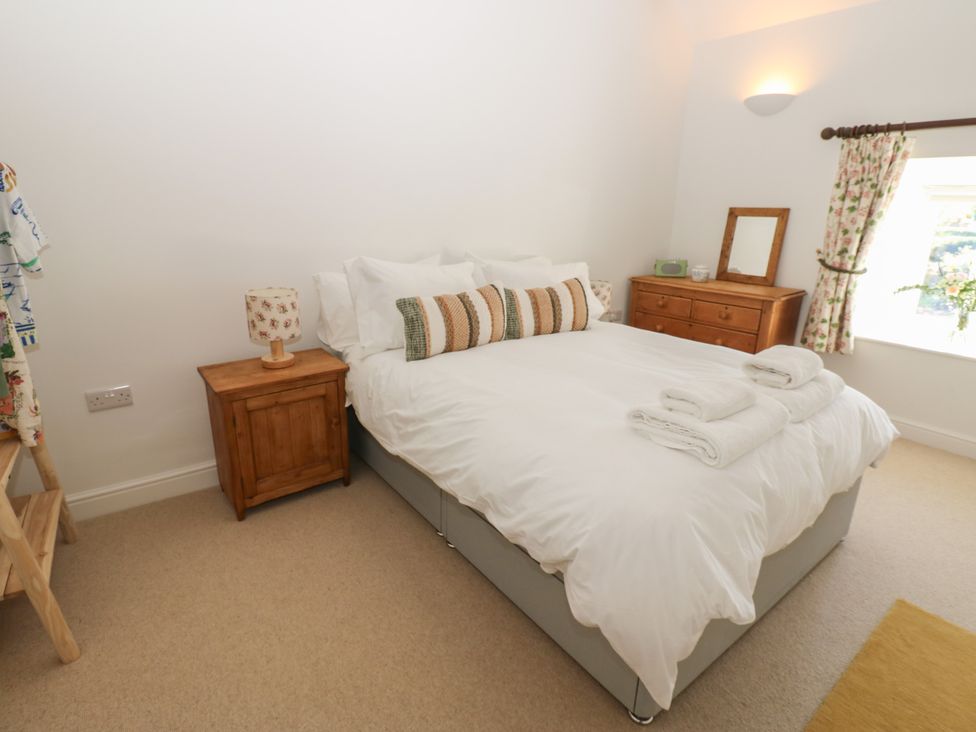 A bedroom with a bed and bedside table at High Meadow Barn in Thornton Rust near Bainbridge