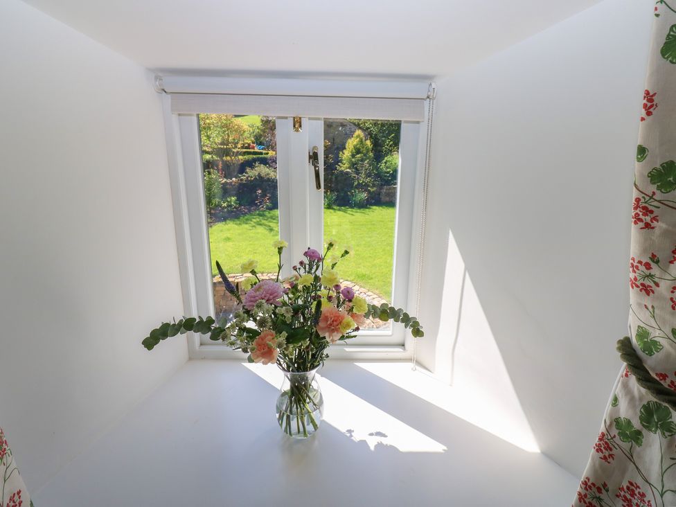 A window with flowers on a table at High Meadow Barn Thornton Rust near Bainbridge