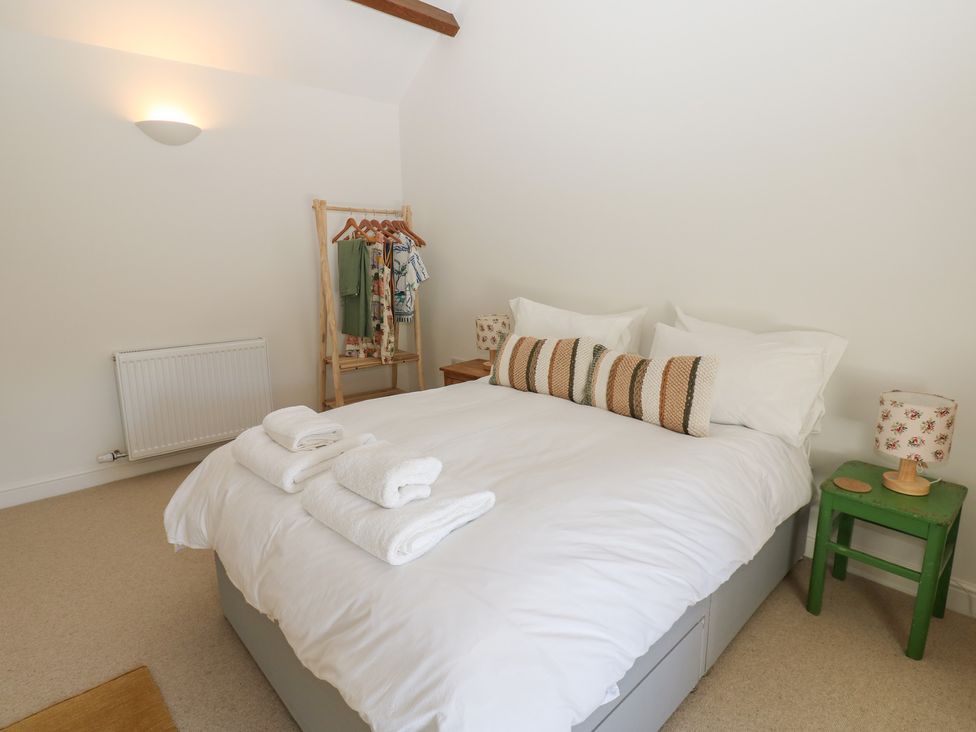 A bedroom with a bed and clothes rack at High Meadow Barn Thornton Rust near Bainbridge