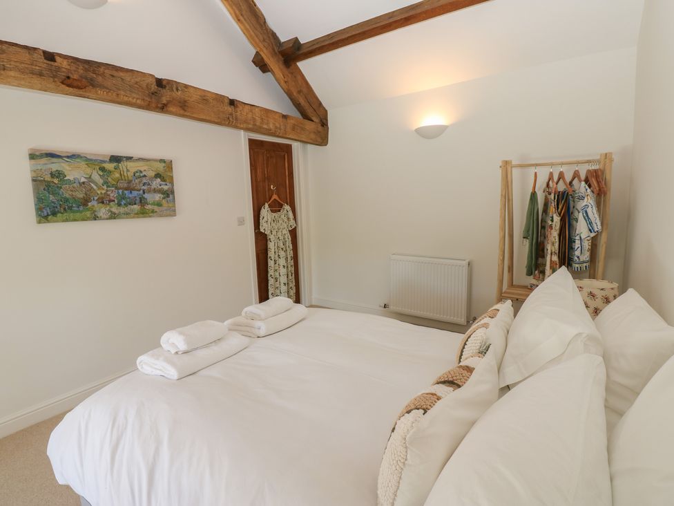 A bedroom with a bed and a coat rack at High Meadow Barn in Thornton Rust near Bainbridge