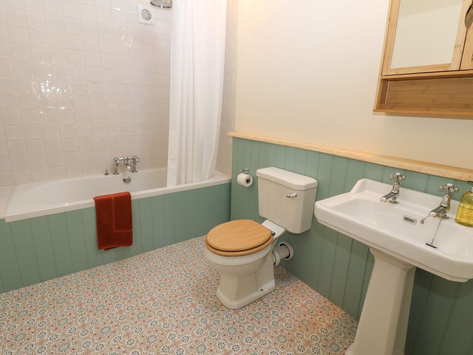 A bathroom with a bathtub, toilet, and sink at High Meadow Barn in Thornton Rust near Bainbridge