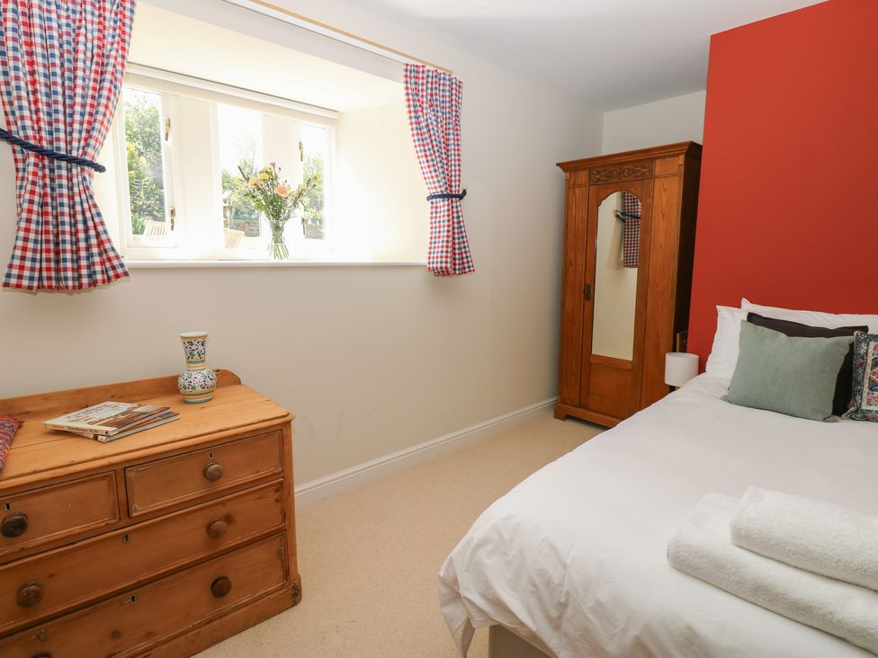 A bedroom with a window, bed, wardrobe, and bedside table at High Meadow Barn Thornton Rust near Bainbridge