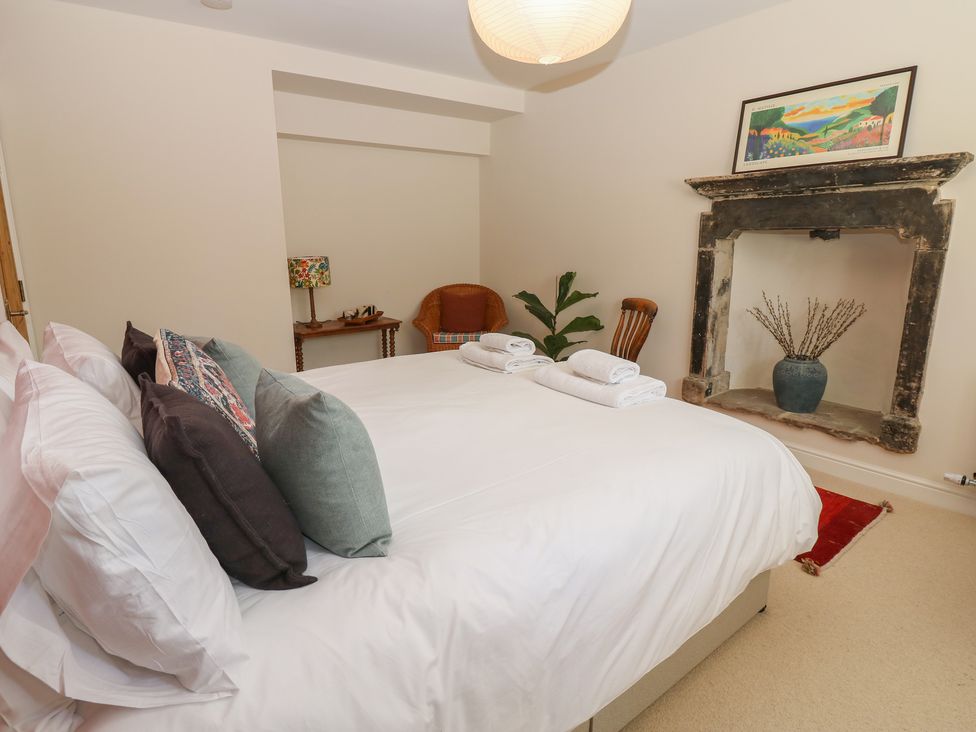 A bedroom with a bed and armchair at High Meadow Barn Thornton Rust near Bainbridge