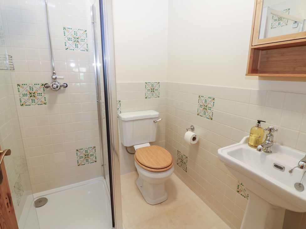 A bathroom with a shower, toilet, and sink at High Meadow Barn Thornton Rust near Bainbridge