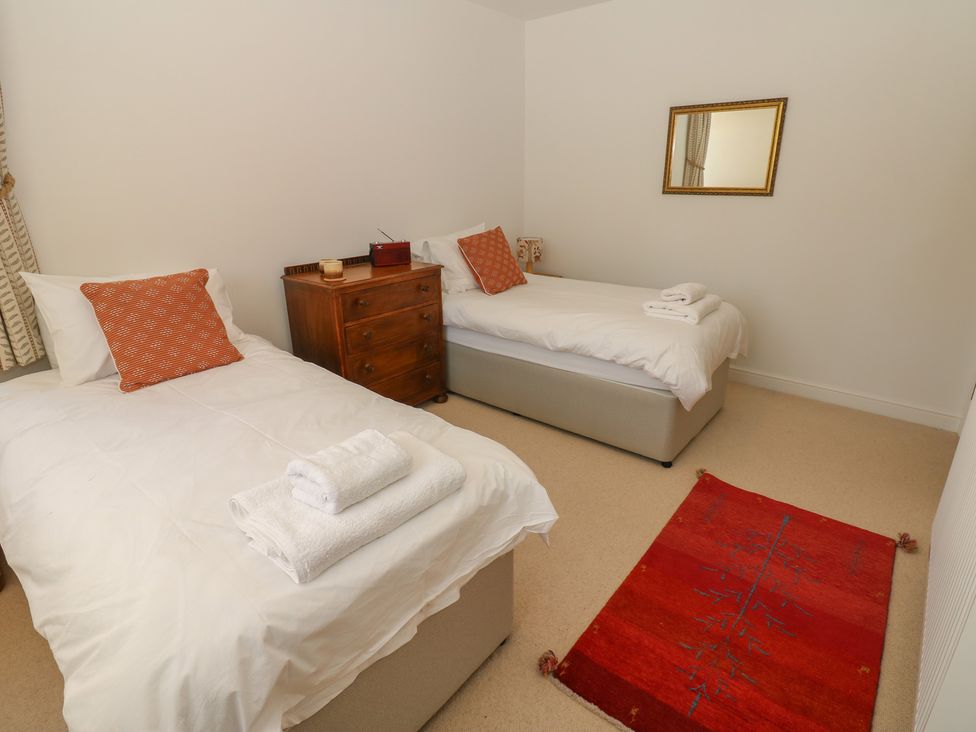 A bedroom with two beds and a rug at High Meadow Barn in Thornton Rust near Bainbridge