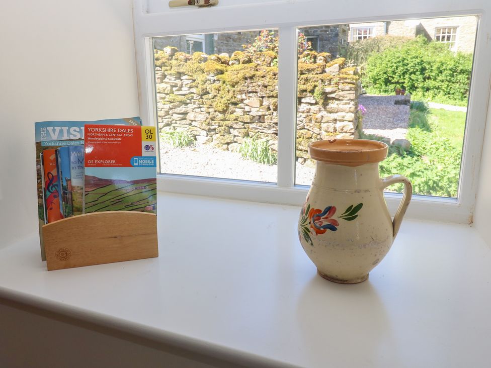 A kitchen window with brochures and a jug at High Meadow Barn Thornton Rust near Bainbridge