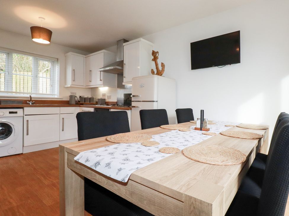 A kitchen with a dining table and chairs at Poldam St Austell