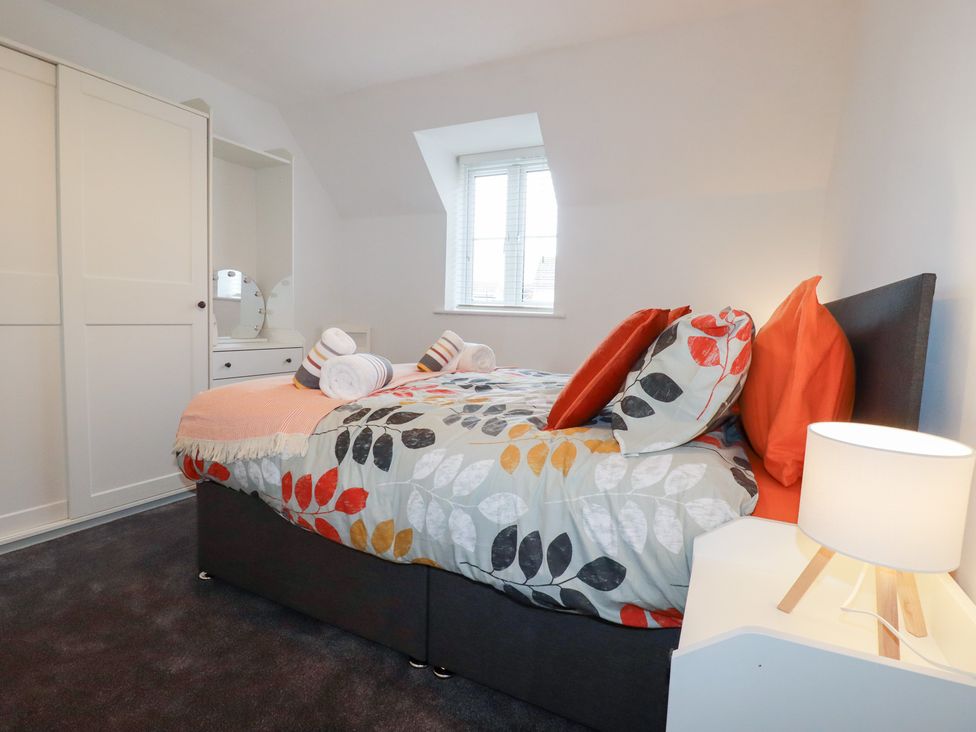 A bedroom with a bed and wardrobe at Poldam in St Austell