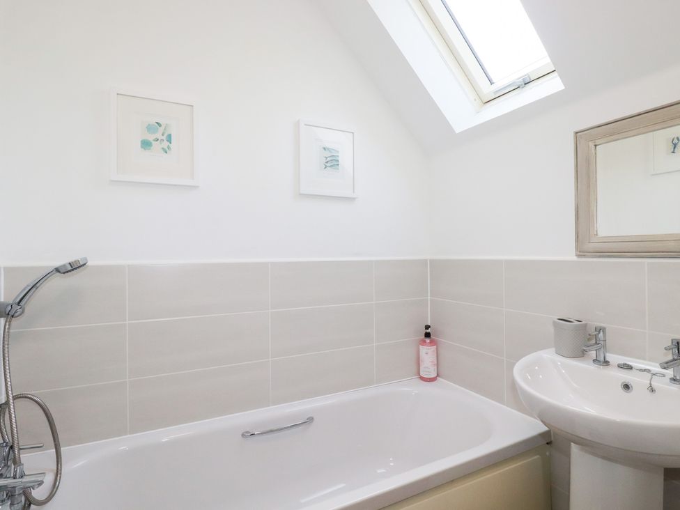 A bathroom with a bathtub and sink at Poldam St Austell