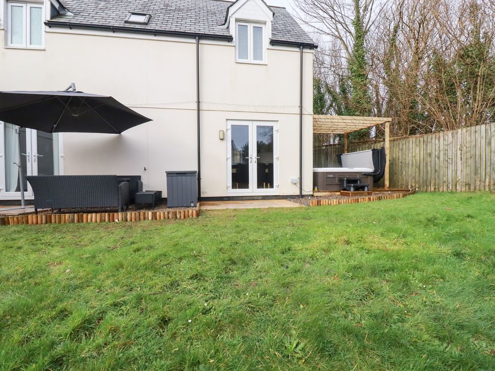 A backyard with a hot tub and outdoor furniture at Poldam in St Austell