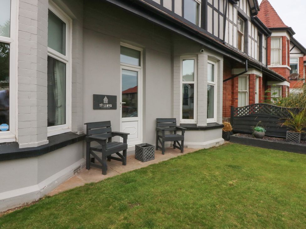 An entrance area with two chairs beside a door at Ty Llwyd in Llandudno