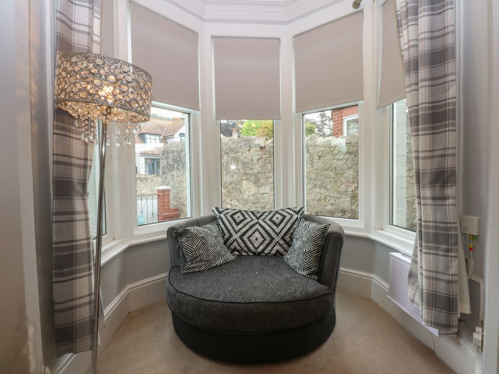 A snug area with a circular sofa and lamp at Ty Llwyd in Llandudno