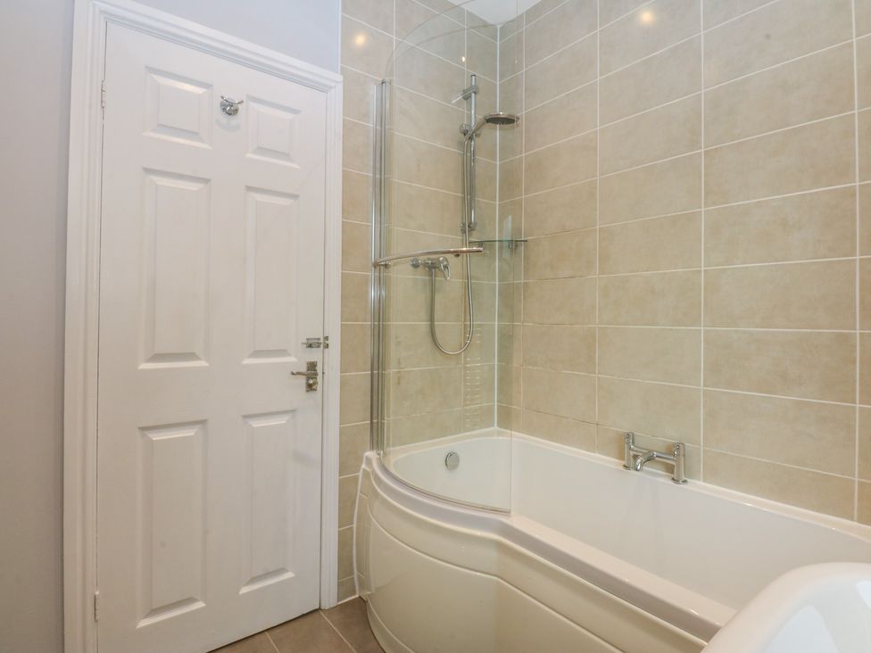 A bathroom with a bath and shower at Ty Llwyd in Llandudno