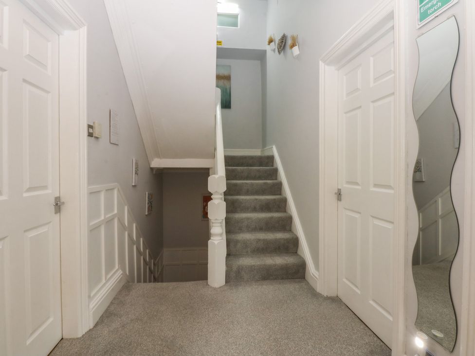 A hallway with stairs and doors at Ty Llwyd in Llandudno