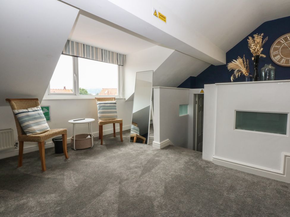 A landing area with two chairs and a small table at Ty Llwyd in Llandudno