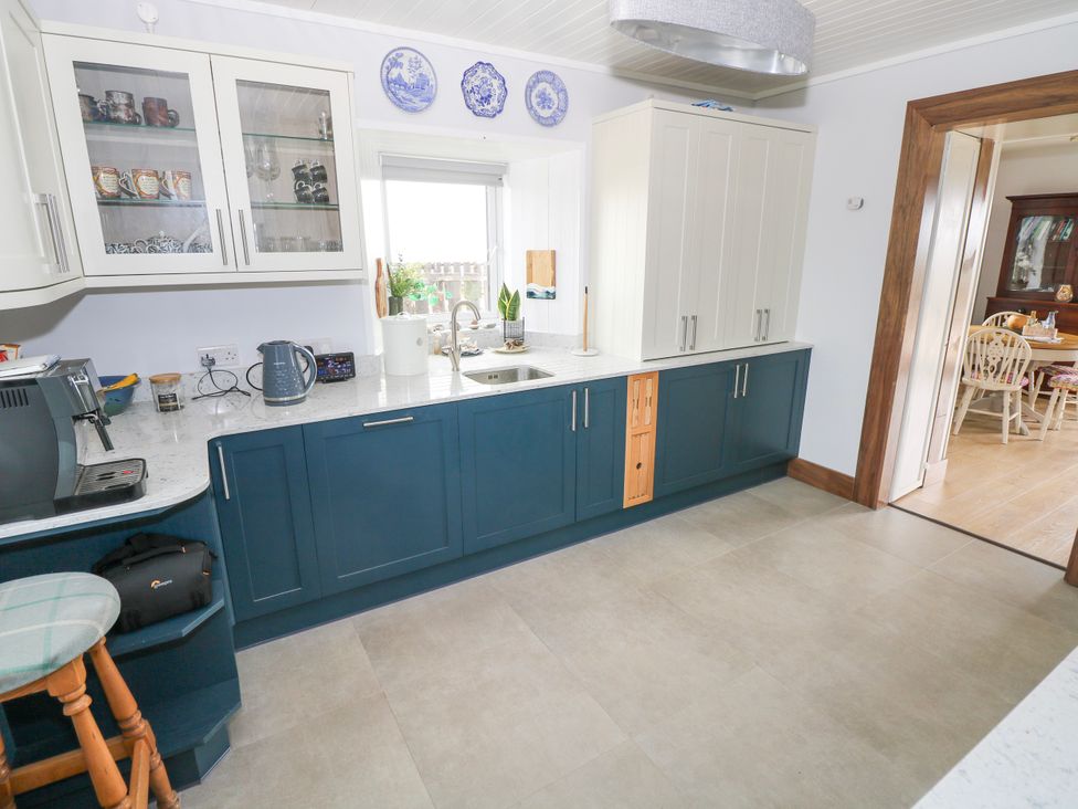 A kitchen with cabinets, a sink, and a coffee machine at Claddagh Tuss Holiday Cottage in Clifton