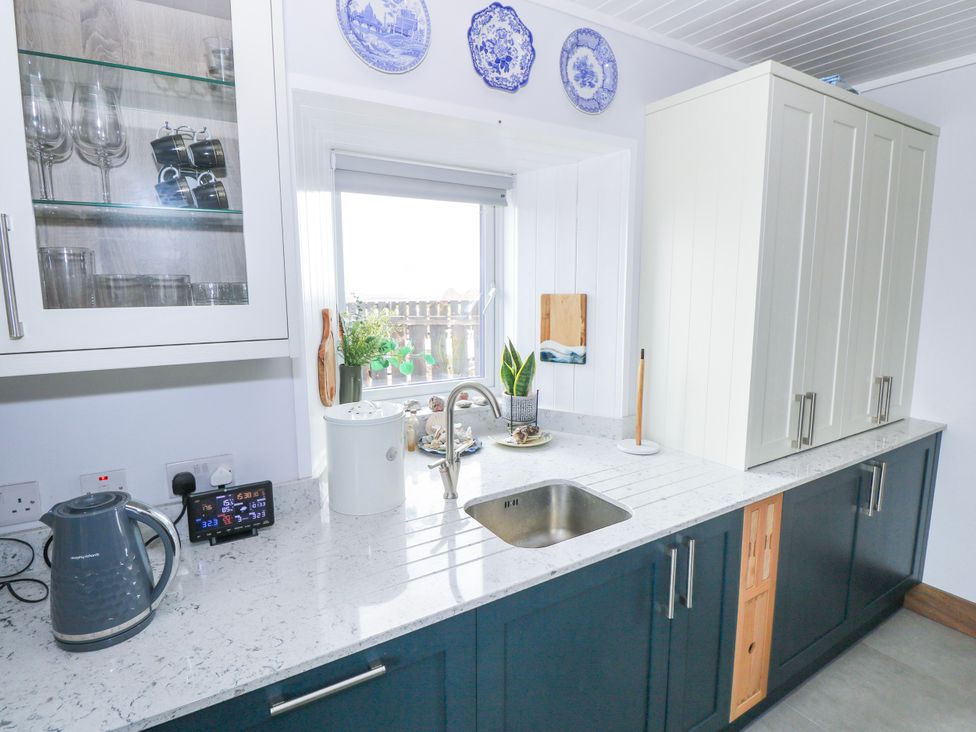 A kitchen with a sink and kettle at Claddagh Tuss Holiday Cottage in Clifton