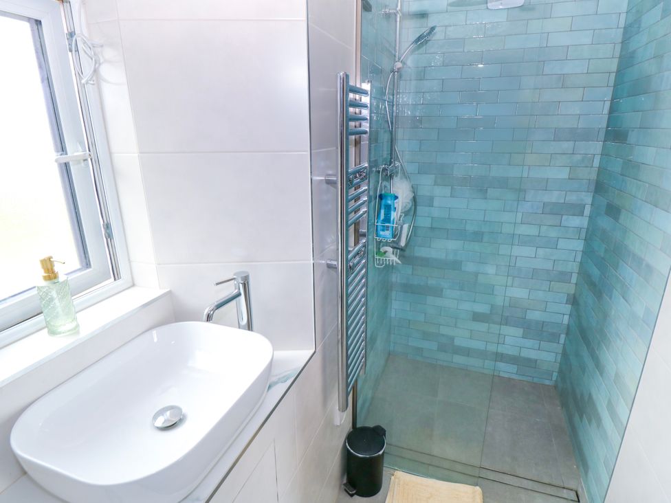 A bathroom with a sink and shower at Claddagh Tuss Holiday Cottage, Clifton