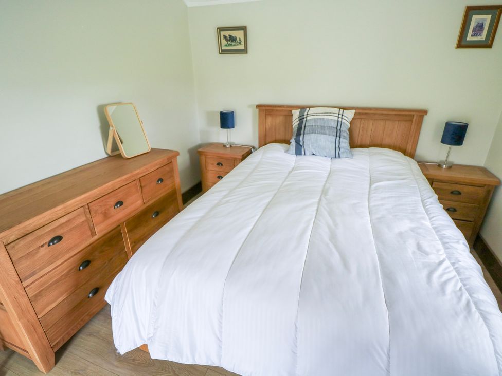 A bedroom with a bed and furniture at Claddagh Tuss Holiday Cottage in Clifton