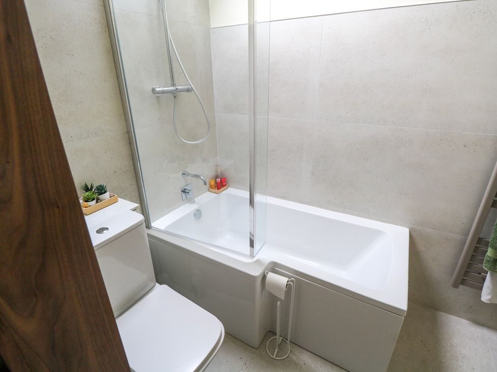 A bathroom with a bathtub and shower at Claddagh Tuss Holiday Cottage Clifton