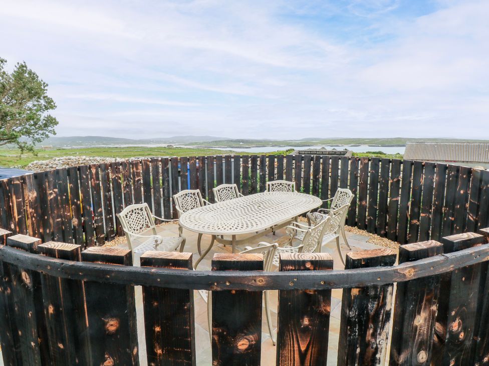 An outdoor area with a table and chairs at Claddagh Tuss Holiday Cottage in Clifton