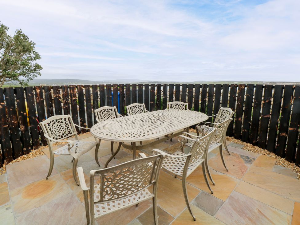 An outdoor dining set with a table and chairs at Claddagh Tuss Holiday Cottage in Clifton