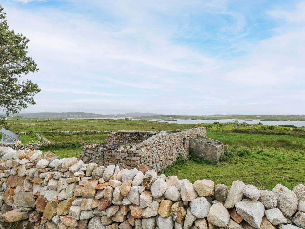 An outdoor view of ruins and grassland at Claddagh Tuss Holiday Cottage in Clifton