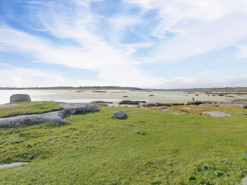 A coastal view with grass and rocks at Claddagh Tuss Holiday Cottage in Clifton