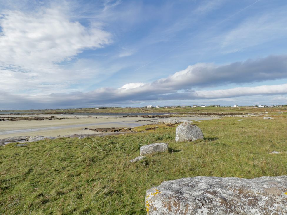 A landscape with rocks and grass near the water at Claddagh Tuss Holiday Cottage in Clifton