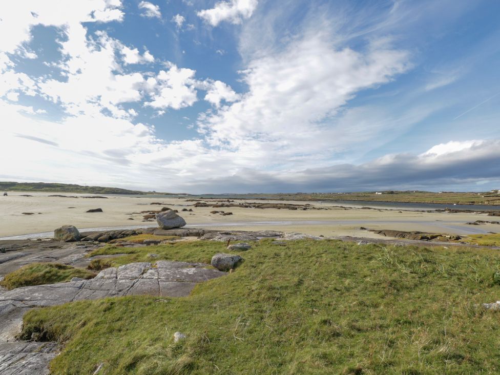 A landscape with rocks, grass, and water at Claddagh Tuss Holiday Cottage Clifton