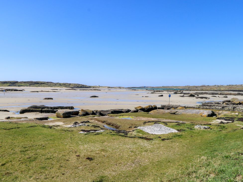 A beach with rocks and water at Claddagh Tuss Holiday Cottage in Clifton