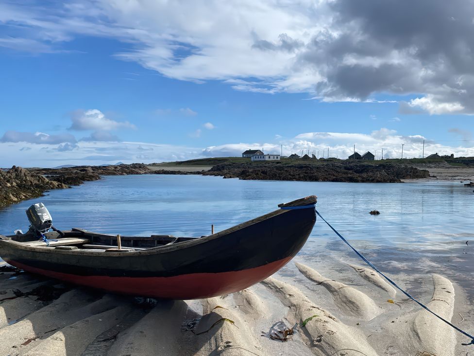 A boat on the sand near water at Nead na bhFáinleog (Swallows’ Nest), Claddaghduff, County Galway