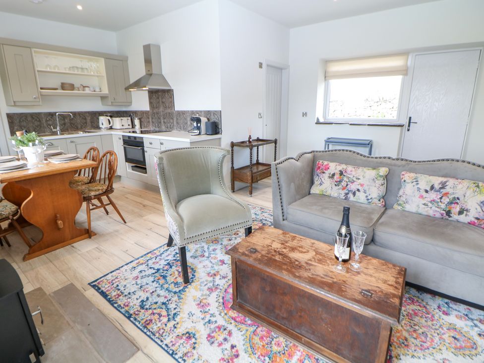 A living room with kitchen elements and dining furniture at The Stables in Stockport