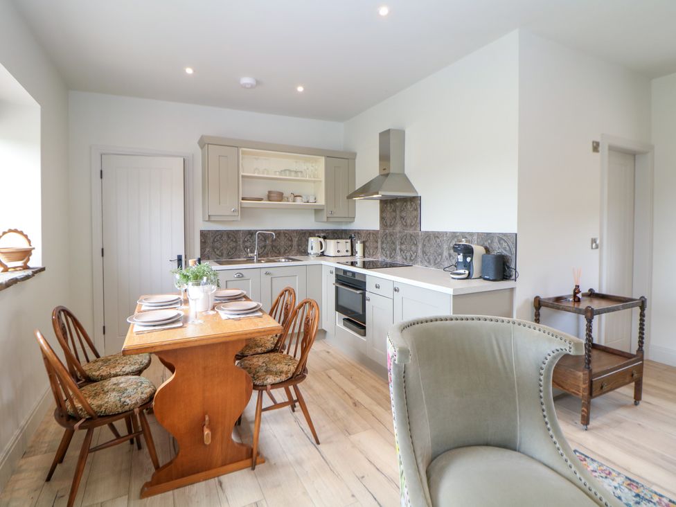 A kitchen with a table and chairs at The Stables in Stockport