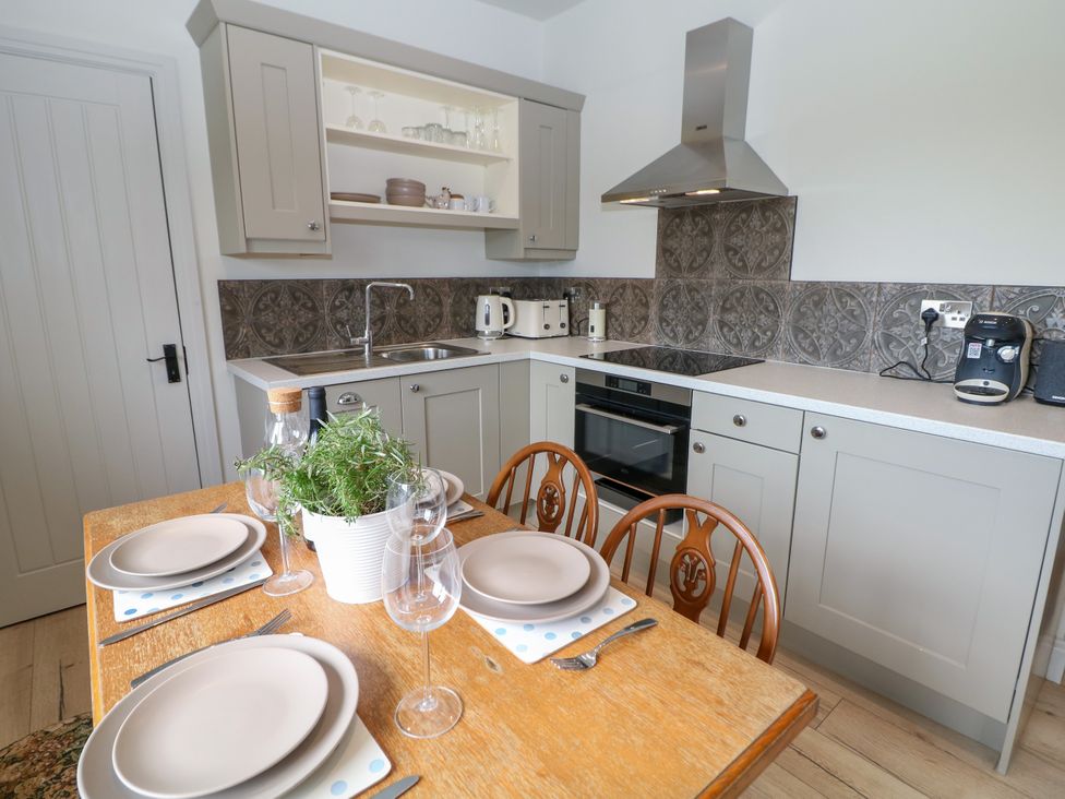 A kitchen with a table set for dining at The Stables in Stockport