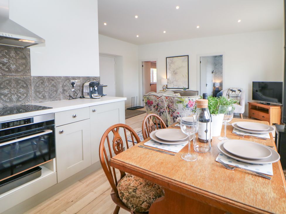 A kitchen with dining table and chairs at The Stables in Stockport