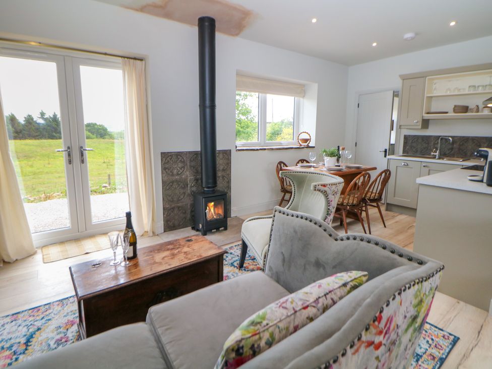 A living room with a stove and dining area at The Stables in Stockport