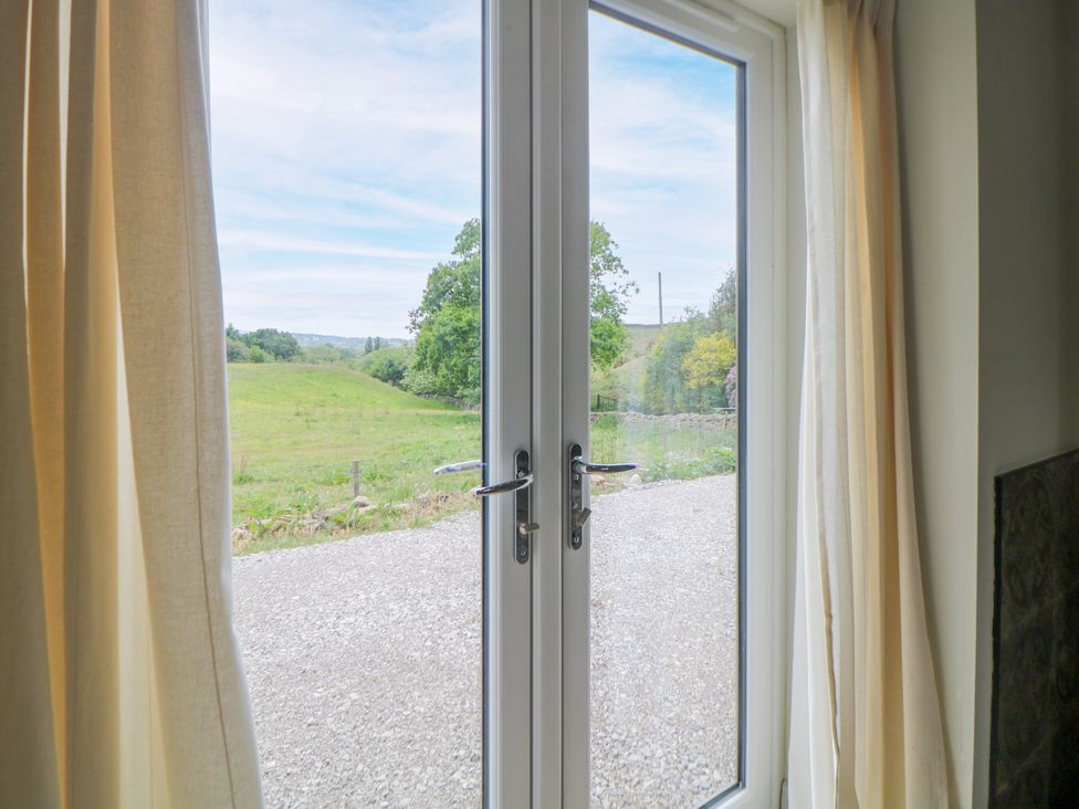 A double door leading to a gravel path and field at The Stables in Stockport