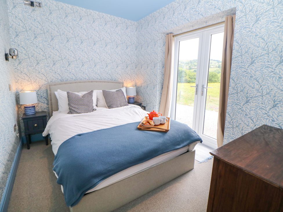 A bedroom with a bed and a tray with tea at The Stables in Stockport