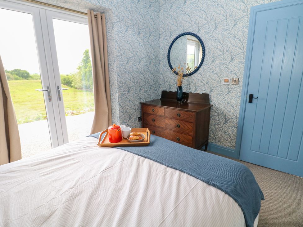 A bedroom with a bed and a dressing table at The Stables in Stockport