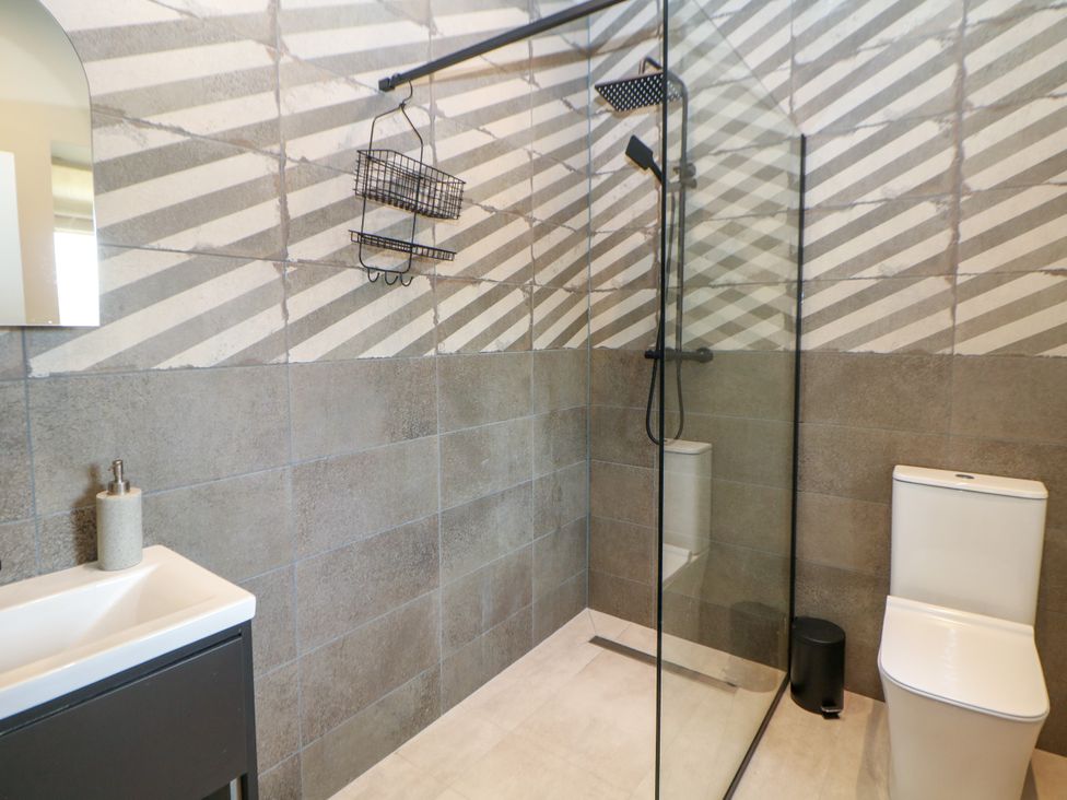 A bathroom with a shower, toilet, and sink at The Stables in Stockport