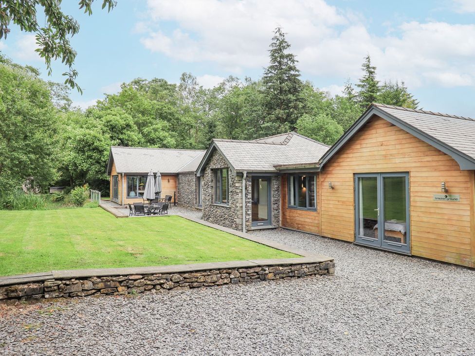 An outdoor view of a house with green grass and trees at Bracken Ground in Coniston